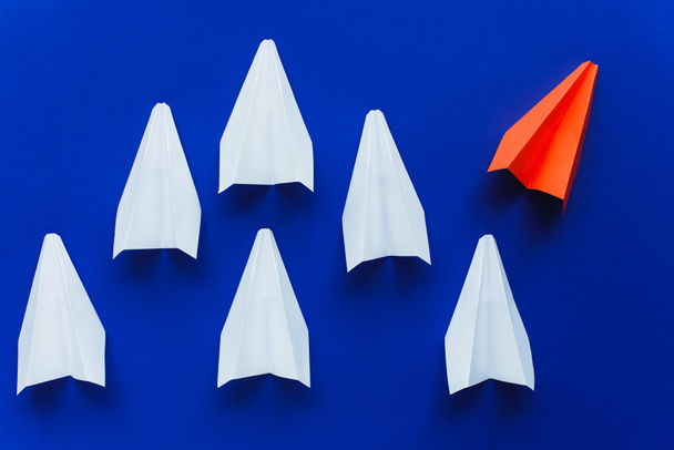 top view of white and red paper planes on blue background, leadership concept  - Foto, imagen