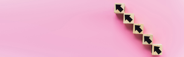 plano panorámico de bloques de madera con flechas negras sobre fondo rosa, concepto de negocio - Foto, Imagen