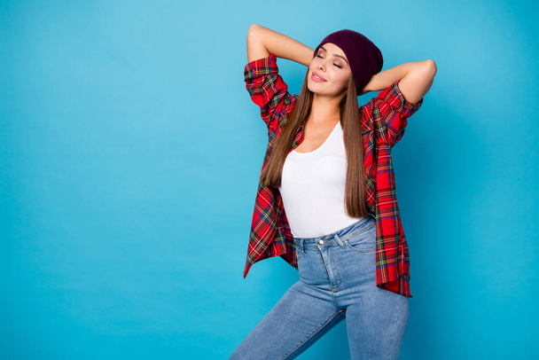Photo of charming stylish lady glad warm spring autumn weather street look eyes closed arms behind head wear casual hat plaid shirt jeans isolated blue color background - Foto, Imagem