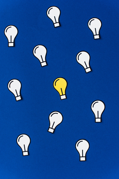 top view of paper light bulbs on blue background, business concept - Photo, Image