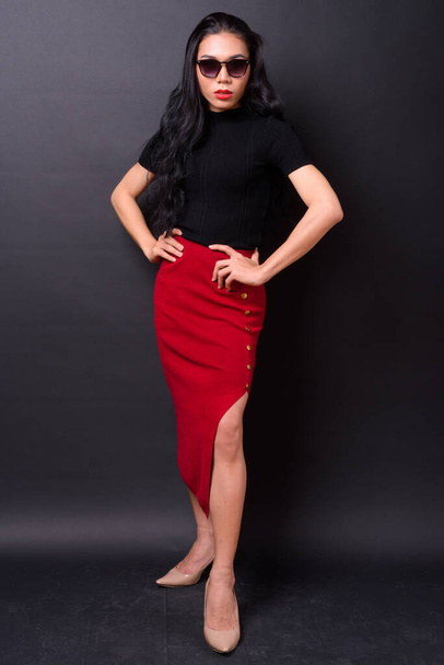 Studio shot of young beautiful Asian transgender businesswoman against black background - Foto, Imagem