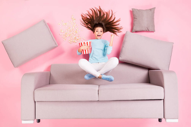 Top view above high angle flat lay flatlay lie concept of nice attractive cheerful cheery glad girl sitting on divan eating snack watching funny series having fun isolated pink pastel color background - Foto, immagini