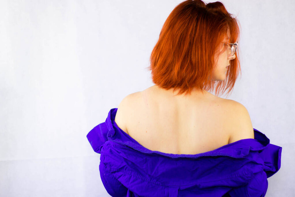 girl with red hair in a blue shirt on a white background - Foto, Imagem