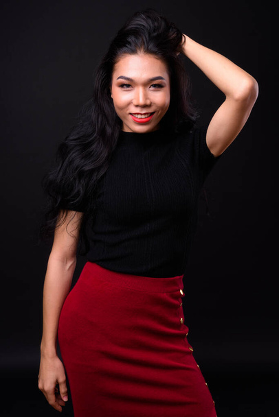 Studio shot of young beautiful Asian transgender businesswoman against black background - Zdjęcie, obraz