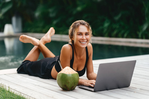 Woman freelance work typing on laptop with fresh coconut . - Foto, Bild
