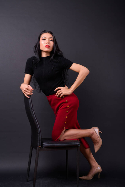 Studio shot of young beautiful Asian transgender businesswoman against black background - Fotoğraf, Görsel