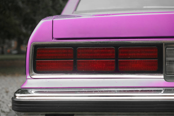brake light of a purple vintage car, bumper of retro automobile, tail lights of blue sedan. rainy weather. autumn season - Fotoğraf, Görsel