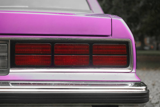 brake light of a purple vintage car, bumper of retro automobile, tail lights of blue sedan. rainy weather. autumn season - Fotoğraf, Görsel