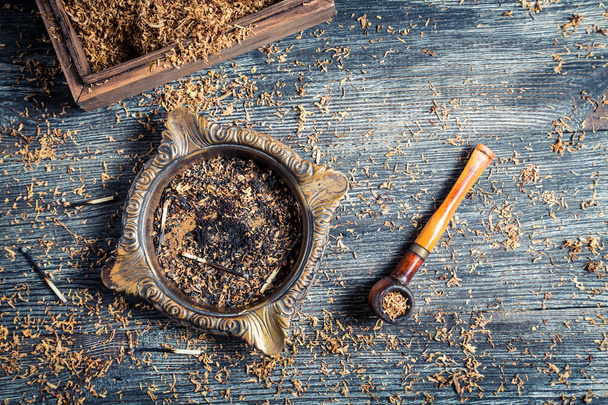 Fresh tobacco in a wooden pipe - Foto, afbeelding