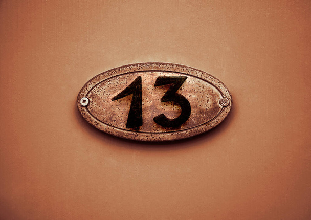 Número 13, matrícula de calle en una fachada. detalle de puerta roja - Foto, imagen