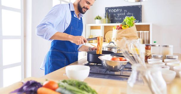 Man preparing delicious and healthy food in the home kitchen - Φωτογραφία, εικόνα