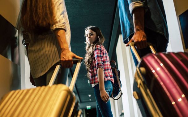 Beautiful happy excited family with a backpack and suitcases in modern hotel - 写真・画像
