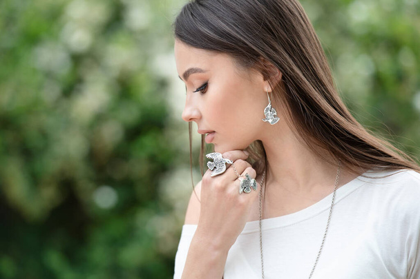 Piękna kobieta w naszyjniku, kolczykach i pierścionku. Model w srebrnej biżuterii. - Zdjęcie, obraz