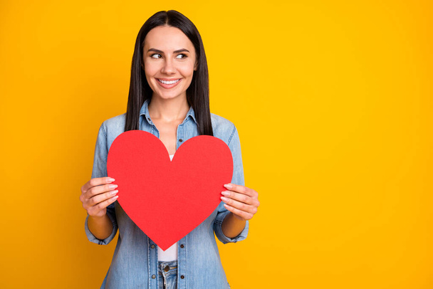 Portrait of her she nice attractive lovely pretty lovable careful cheerful girlfriend holding in hands big large paper heart cupid date isolated on bright vivid shine vibrant yellow color background - Fotografie, Obrázek
