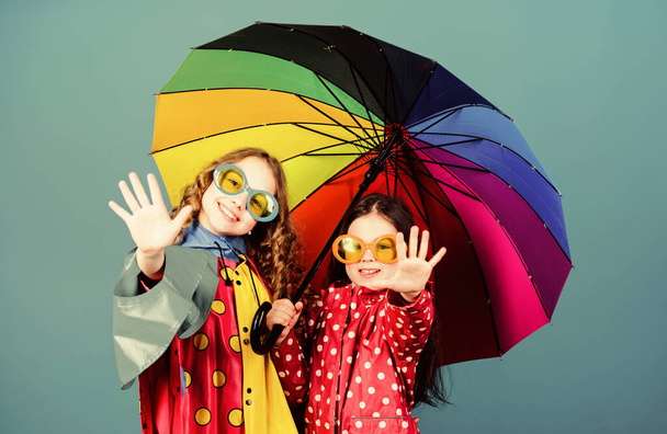 family bonds. Small girls in raincoat. autumn fashion. cheerful hipster children, sisterhood. rain protection. Rainbow. happy small girls with colorful umbrella. Resting after long day hiking - 写真・画像