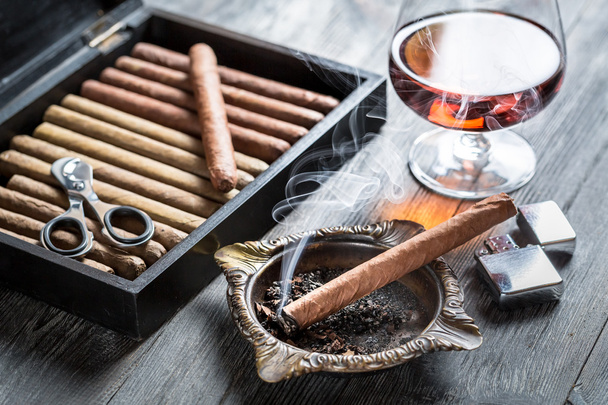 Burning cigar in ashtray and cognac - Φωτογραφία, εικόνα