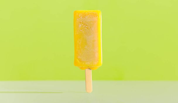 Sárga fényes jégkrém egy pálcikán. Citromíz - Fotó, kép