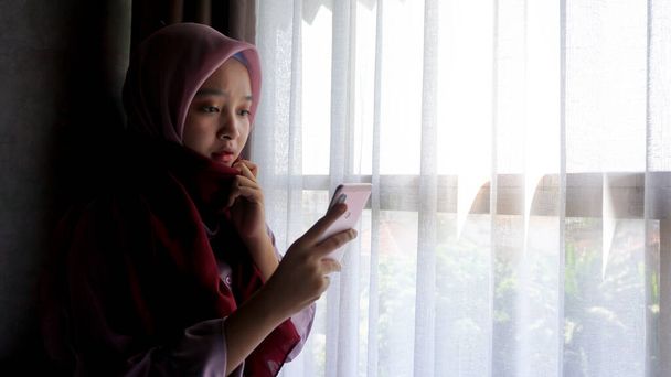 Chica asiática jugando al teléfono en el dormitorio
 - Foto, imagen
