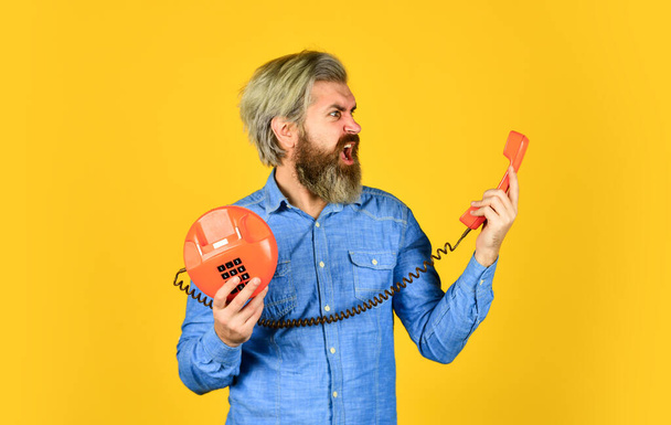 Connecting people is our business. young man talking on telephone. senior man hipster showing old telephone. brutal guy with telephone. mature bearded man talk on retro phone. vintage in modern life - Photo, image
