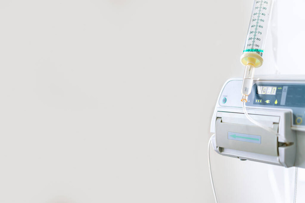 Modern automatic Infusion pump for infuses fluids medication or nutrients sodium chloride saline solution fluid iv with tubing scale irrigation transparent drip with copy space - Photo, Image