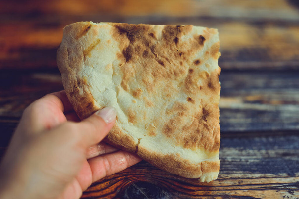 jídlo z kavkazské gruzínské kuchyně,, dívka drží kousky v rukou. Kousek chleba s pitou v ruce. Fotografování potravin - Fotografie, Obrázek