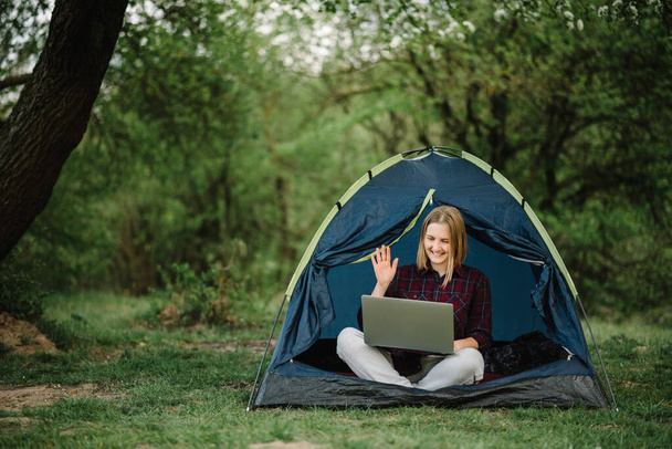 Communicate with relatives, family online on laptop in tent in nature. Female briefing the team at the conference or remote work consultation, woman worker speak talk on video call with colleagues. - Fotografie, Obrázek