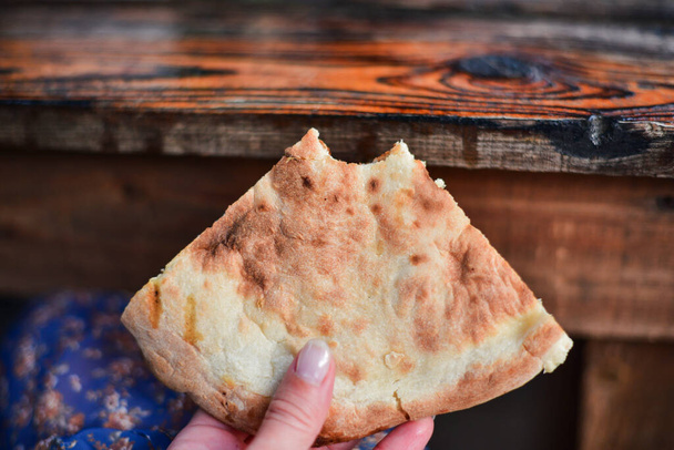 a kaukázusi grúz konyha étele, egy lány kezében tartja a darabokat. Egy darab pitakenyér a kezemben. Élelmiszer fotózás - Fotó, kép