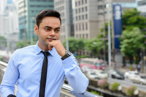 Portrait of young handsome Indian businessman in the city - Foto, imagen