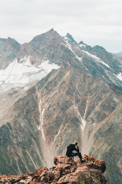Escursioni e arrampicate. Turista in posa sulla cima di una sporgenza di montagna. - Foto, immagini