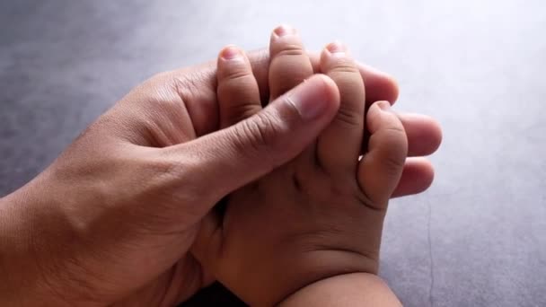 Vater hält Hand des Babys, aus nächster Nähe . - Filmmaterial, Video