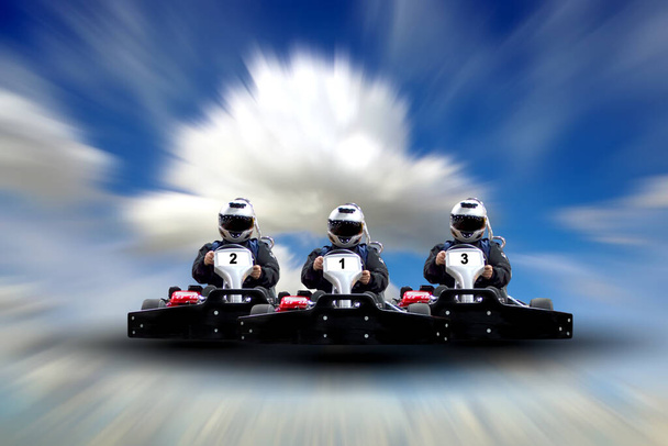 Tre piloti Go kart speed rive indoor race contro un cielo blu con nuvole. Ricevuto. Go kart indoor, cart racing fast, car where gokarting, we speed racing, racers banner. - Foto, immagini