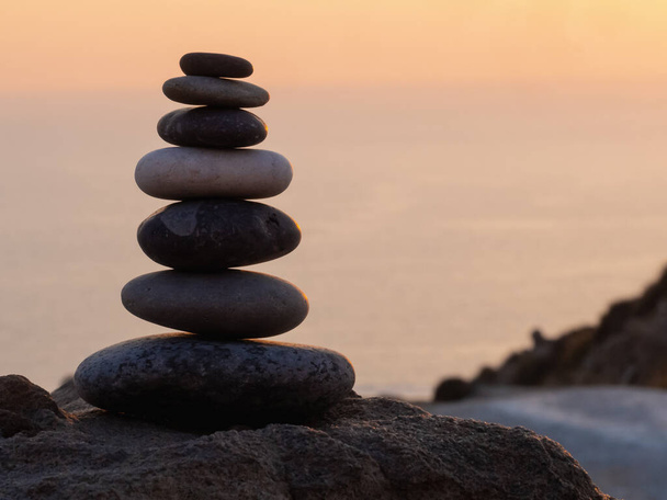 cairn al tramonto, equilibri di pietre, piramide di pietre al tramonto, concetto di equilibrio della vita, armonia e meditazione - Foto, immagini