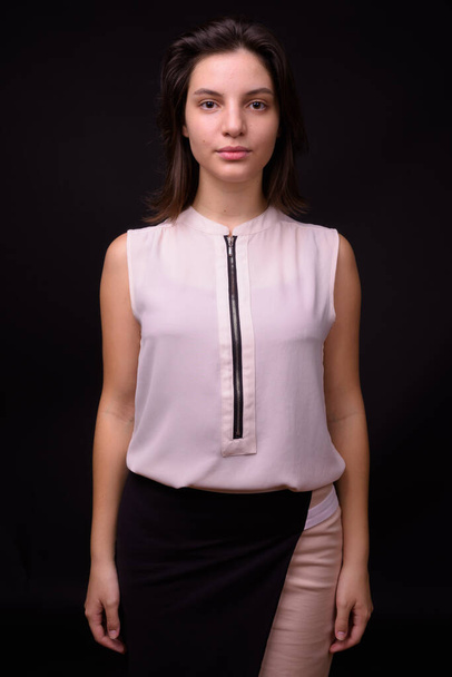 Studio shot of young beautiful businesswoman against black background - Photo, image