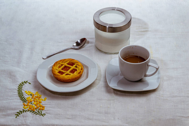 still life with cup of coffee and chocolate cake on white tablecloth - Fotografie, Obrázek