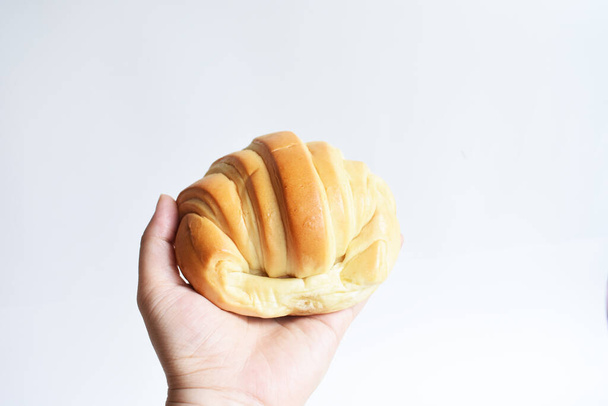Una donna che tiene in mano un delizioso croissant formaggio / burro per una sana colazione vegana, soleggiata, panificio, fatto in casa, cibo spazzatura, fast food - Foto, immagini