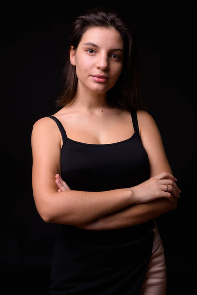 Studio shot of young beautiful woman against black background - Fotografie, Obrázek