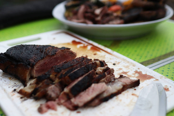 Snijd medium rare rib eye steak op een bord. - Foto, afbeelding