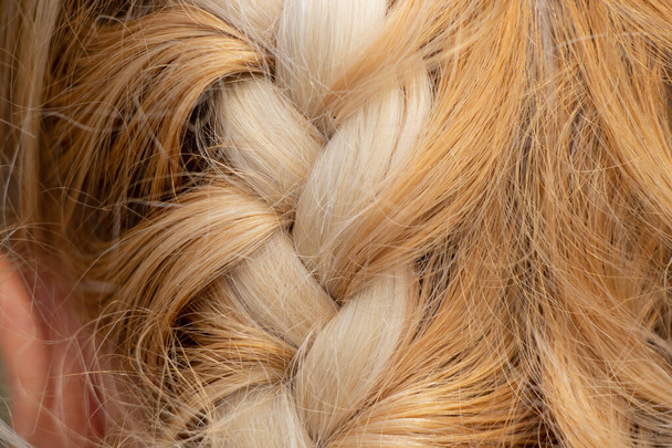 geflochtene Stachel auf dem Kopf eines jungen blonden Mädchens Nahaufnahme - Foto, Bild