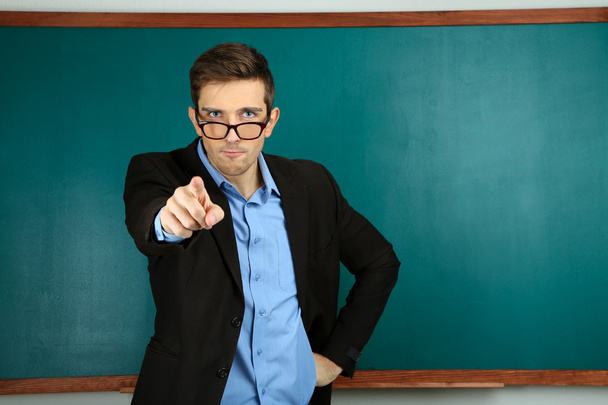 νεαρός δάσκαλος κοντά chalkboard σε σχολική τάξη - Φωτογραφία, εικόνα
