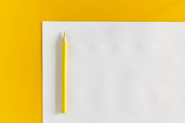 Yellow pencil and blank sheet of white paper on a yellow background - Foto, Imagem