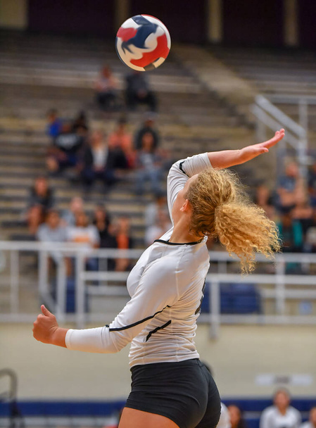 Молодая девушка делает удивительные игры во время игры в волейбол - Фото, изображение