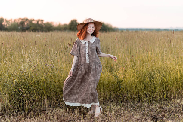 redhead model posing in a meadow at sunset - Photo, Image