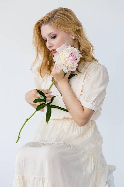 beautiful sensual girl with long blonde hair in dress with a bouquet of pink peonies flowers. oncept of feminity  - Fotografie, Obrázek