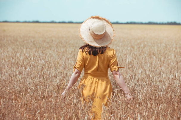 woman in yellow sundress walking by wheat field. summer time - Foto, Imagem