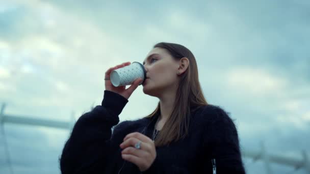 Mädchen trinken Kaffee auf der Straße. Frau kontrolliert Zeit auf Armbanduhr - Filmmaterial, Video