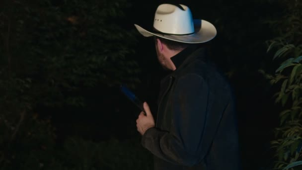 Man met cowboyhoed verstopt zich met een pistool. - Video