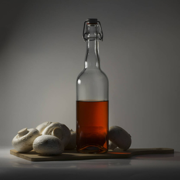 Red wine bottle on wooden board with mushrooms - Fotografie, Obrázek
