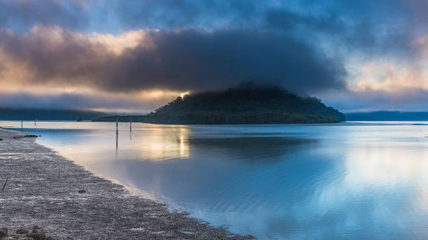 A foggy start to the day with clouds over the river and islands at Mooney Mooney on the Hawkesbury River, Central Coast, NSW, Australia - Фото, изображение