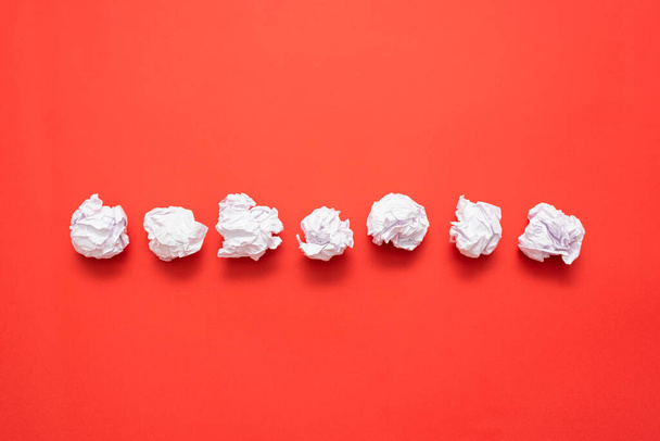 Crumpled paper leaf ball on the red flat lay background with copy space. - 写真・画像