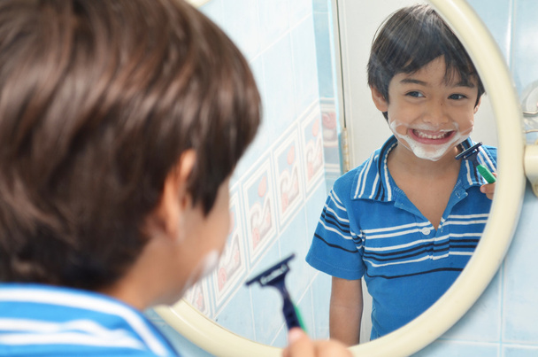 Маленький хлопчик робить вигляд, що голиться у дзеркалі
 - Фото, зображення